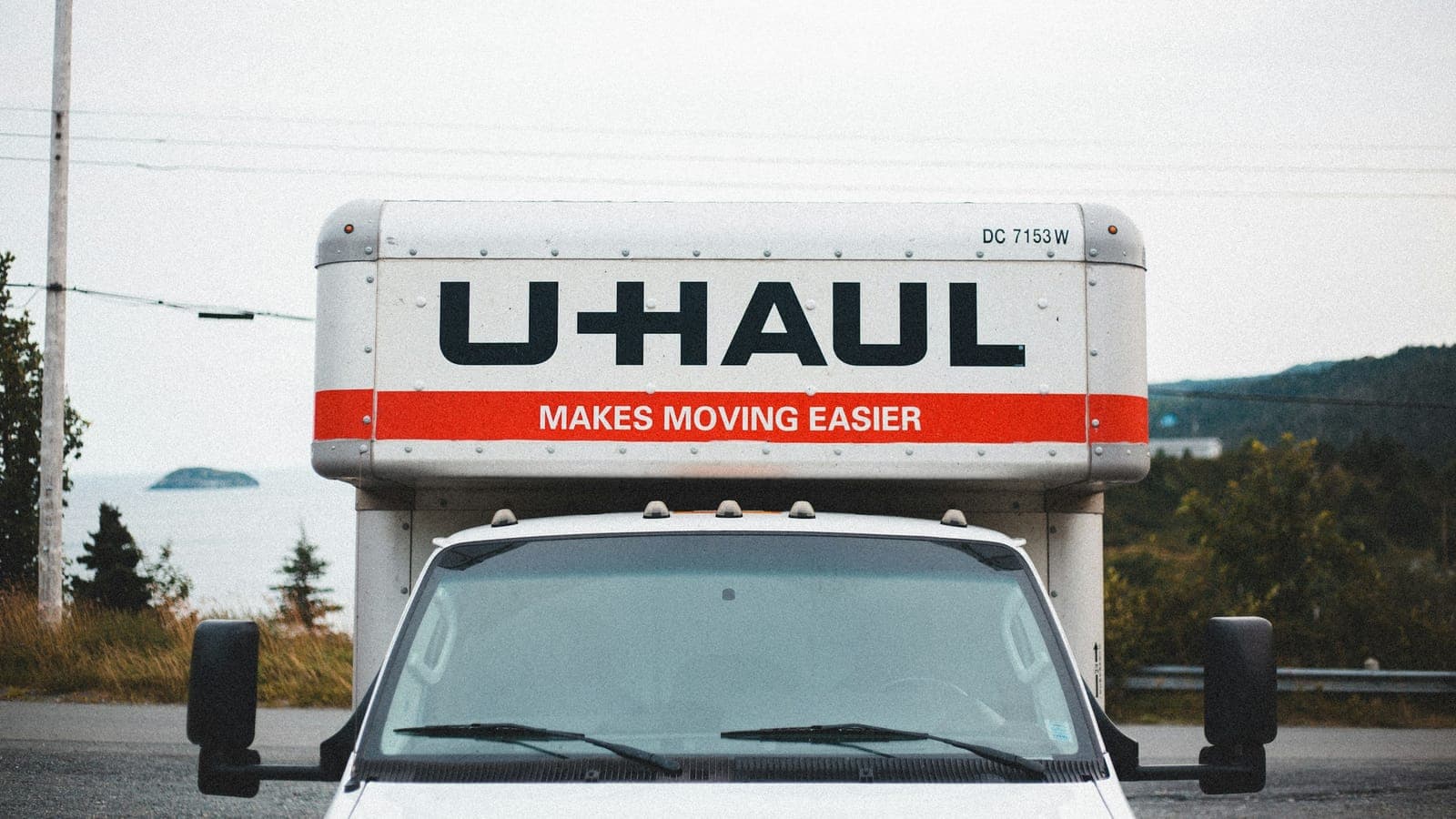 Professional movers loading a moving truck on a Denver street with the Front Range and downtown skyline in the background
